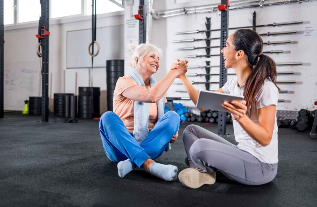 Trainer giving Hi-five to senior woman that is very satisfied to her PTA provided by the Best PTA staffing company in New York|physical therapists